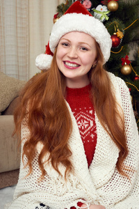 圣诞节装饰中的红发女郎肖像。家庭内部与冷杉树和礼物。新年前夕和寒假概念