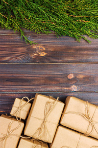 许多礼品盒上的深色质朴的木制背景与复制空间。圣诞树树枝。圣诞 conceps