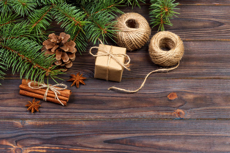 圣诞礼物盒和冷杉分行与肉桂和茴香在质朴的木制背景。平躺。季节性问候的概念。冬季假期