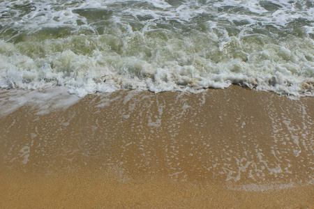 天然背景纹理。沙滩背景上的软海浪。 沙滩上的软浪。 自然背景和文字的地方。