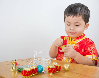 男孩佩带的中国人在桌上玩圣诞节玩具