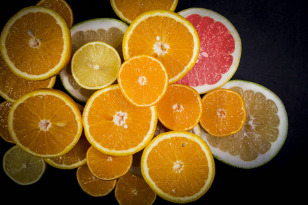 柑橘类水果橙柠檬葡萄柚柑桔石灰在黑暗的背景下。 水果食品背景。 新鲜柑橘类水果