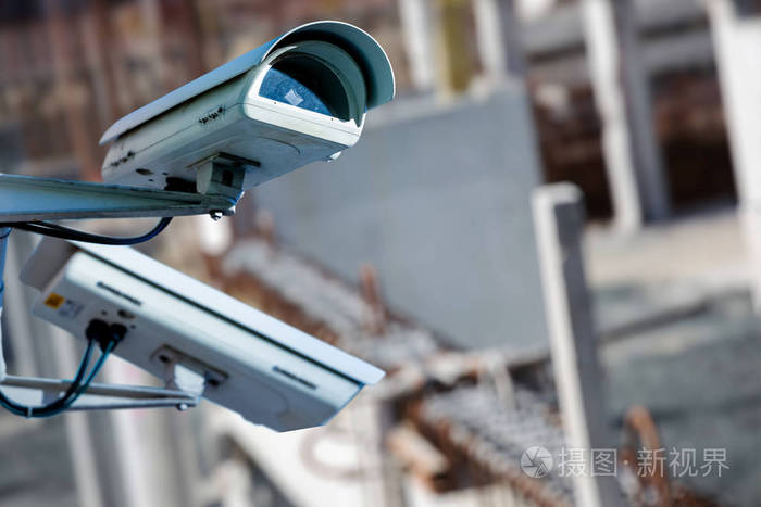 保安闭路电视摄像机或监控系统与建筑工地上模糊的背景