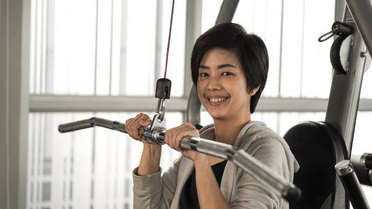 亚洲短发女子健身训练机微笑面图片