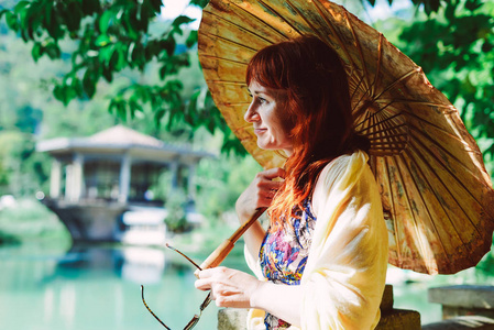 redhaired 美丽的女人带着一把中国雨伞周游世界, 爱中国, 在公园散步