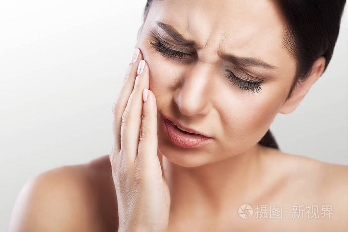 牙齿问题女人感觉牙痛一个美丽的悲伤女孩的特写患有