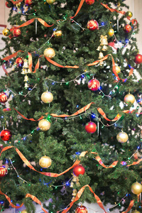 节日, 自然, 庆祝的概念。云杉准备圣诞树和精心装饰的精彩球在不同的 coloures, 灯和红丝带