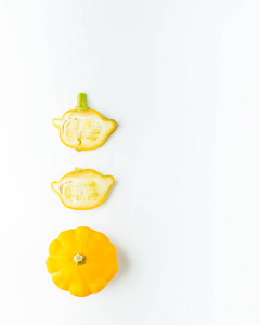 创意布局模式由小黄色南瓜制成。 平躺着。 食物概念。 白色背景上分离的蔬菜。 蔬菜抽象背景