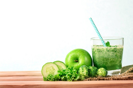 健康新鲜的绿色冰沙汁在玻璃瓶在木头