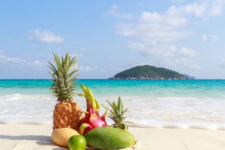 热带水果在沙滩上对绿松石海。四