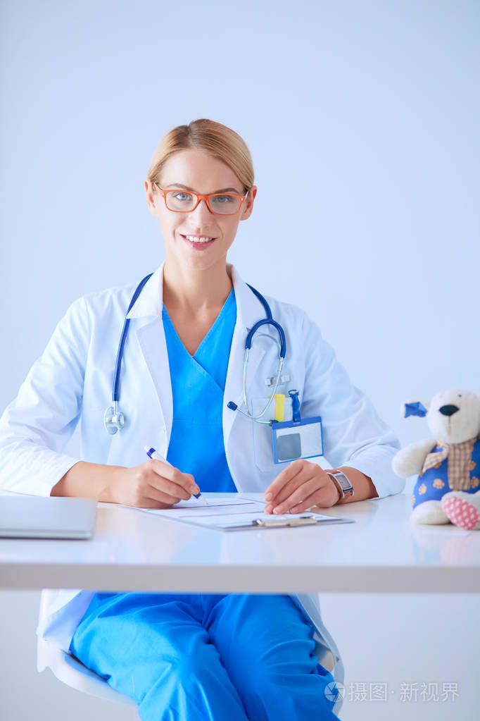 年轻美丽微笑的也是坐在办公桌前女医生