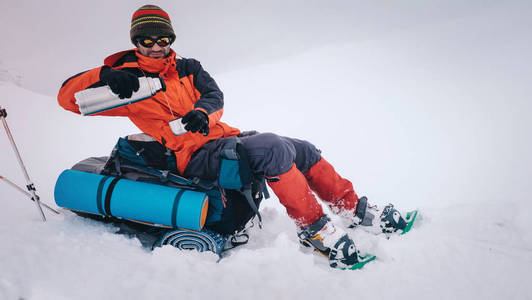 男人用背包和雪在冬天山徒步