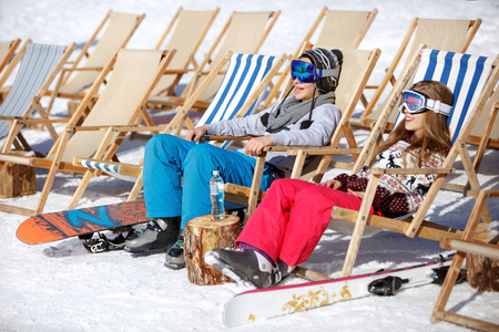 男孩和女孩坐在太阳躺椅滑雪地形