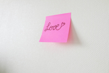 粉红色纸棒笔记与爱的文字写在白色背景上，伟大的任何用途。