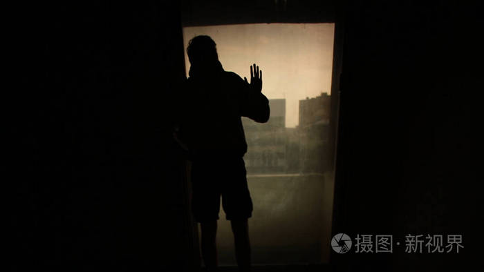 房间里一个孤独的年轻人的剪影.孤独的概念