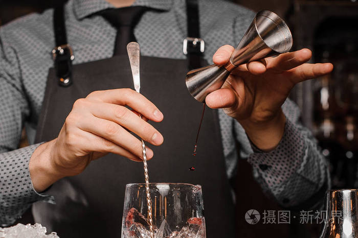 酒保在衬衣,领带和围裙做酒精饮料