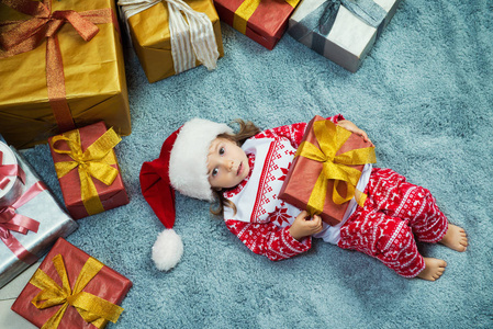 快乐的小女孩躺在手中的礼物, 顶视图, 圣诞节