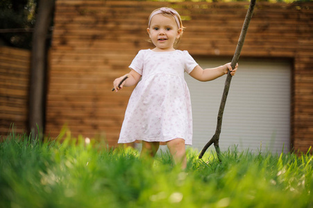 漂亮的小女孩穿着可爱的粉红色的礼服走在草地上