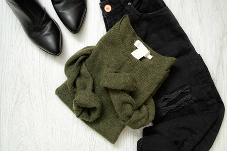 绿色毛衣, 黑色牛仔裤和鞋子。时尚理念