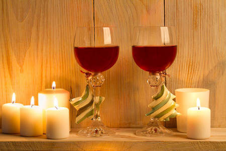 两杯带圣诞配件的葡萄酒放在木架上。 新年和圣诞节的概念背景。 温馨的家
