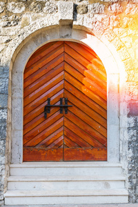 古板砖墙上的旧木门。 古董门上的阳光