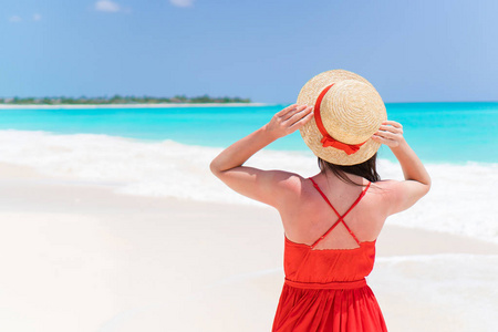 在热带海滩度假期间戴帽子的年轻女子。beautidul 女孩户外观
