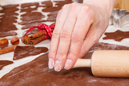 妇女的手用擀面杖烘烤圣诞曲奇饼或姜饼