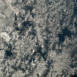 纹理背景图案。 玻璃上的霜状图案。 从雪花中拍摄的宏图。 抽象的冬季背景。 这是玻璃冬季窗户上的霜状图案。