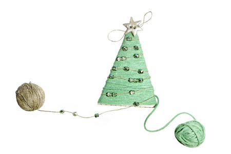 白色背景上孤立的手工圣诞树。 用线做的装饰，用珠子装饰。