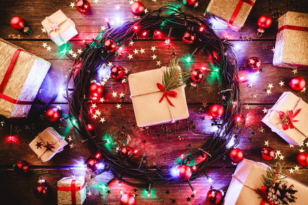 木制背景，五颜六色的星星和星星被礼物和玩具包围。 在中心是白色的节日信息。 上面的风景。