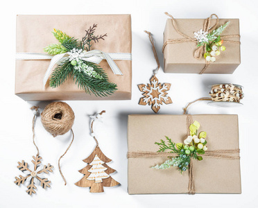经典的圣诞礼品盒, 在棕色的纸与玩具和新年装饰白色的礼物。圣诞贺卡背景