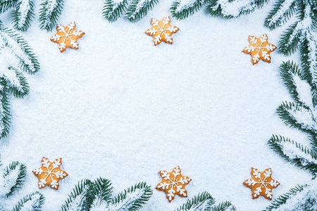 圣诞背景的姜饼饼干与雪和树枝。自由空间