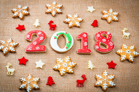 圣诞节姜饼饼干雪花和2018在粗麻布背景与拷贝空间。假日庆祝和烹调概念。圣诞快乐明信片