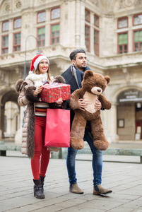 美丽的情侣在街上散步, 带着圣诞礼物