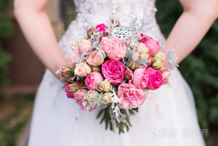 新娘手中捧着粉红色玫瑰的婚礼花束