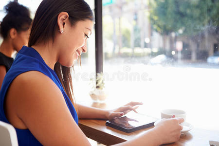 咖啡店使用数码平板电脑的女商人