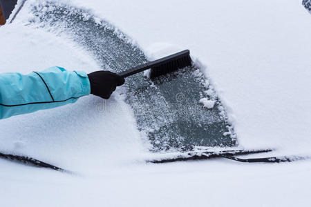 女人在清理车上的雪