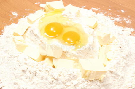 面粉碎鸡蛋和放在桌上的一块人造黄油