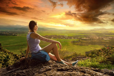 女人望着阳光明媚的山谷边上的悬崖