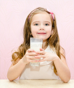 可爱的小女孩带着一杯牛奶