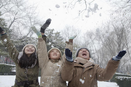 一家人在公园里向空中飞雪图片