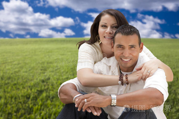 深情的西班牙裔夫妇在草地上拥抱