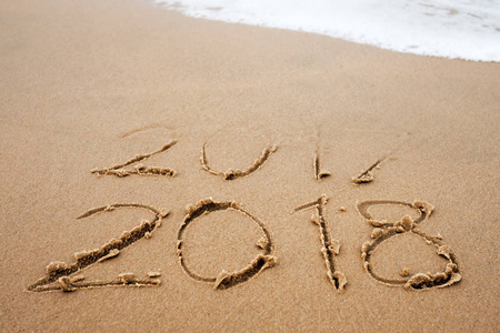假期的概念。新年快乐2018在海边替换2017