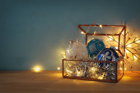 在木桌上的老式玻璃盒子里的圣诞节日装饰品的形象