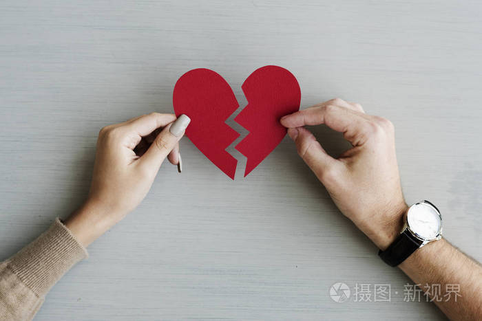 双手捧着破碎的纸心原始照片