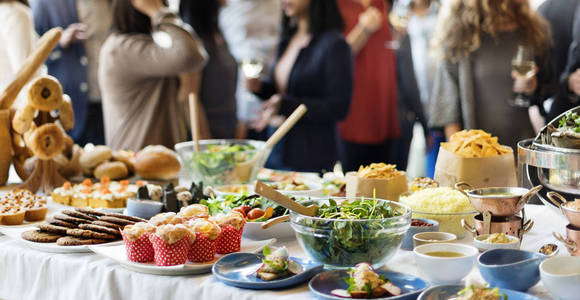 摆桌子桌子上摆着食物,一群形形色色的人在一起吃午饭,原始照片照片