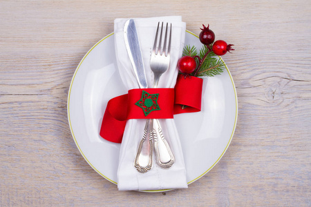 圣诞桌设置与盘子餐具和红色丝带。 寒假和节日背景。 平安夜晚餐新年食物午餐。 上方水平的视图