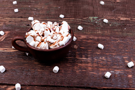 热巧克力与棉花糖在棕色杯在木背景。复制空间
