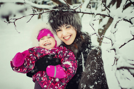 母亲与女儿在冬天公园乐趣