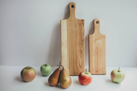 健康食品木质板材, 在木制背景下切割有机生果。水果沙拉或零食的切片配料的顶端视图苹果, 梨, 坚果, 柿子